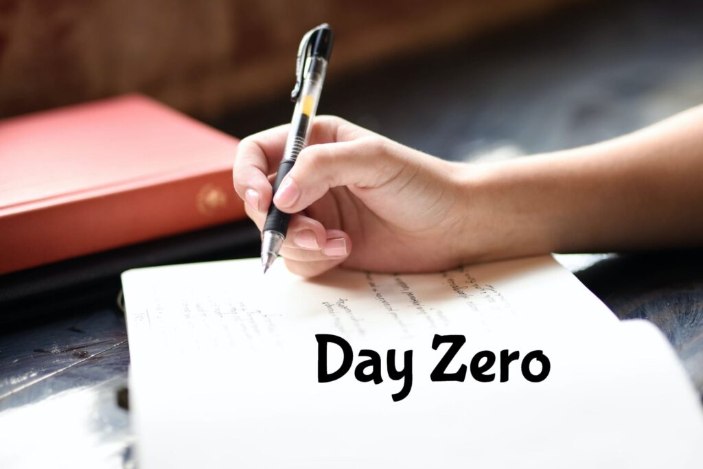 pen in hand writing in a book day zero